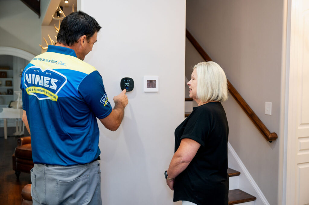 Vines technician speaking with a homeowner about their new thermostat