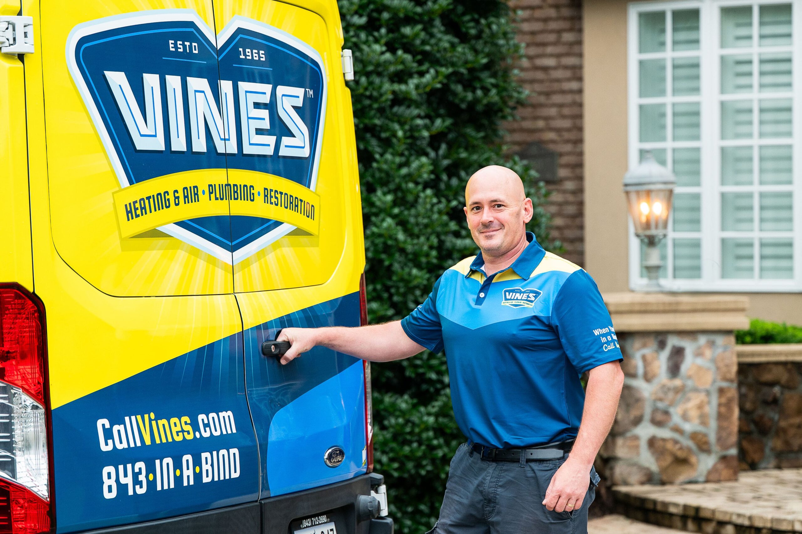 Vines technician standing outside a work van