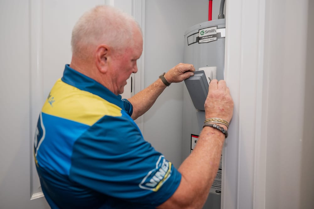 Vines technician opening traditional water heater.