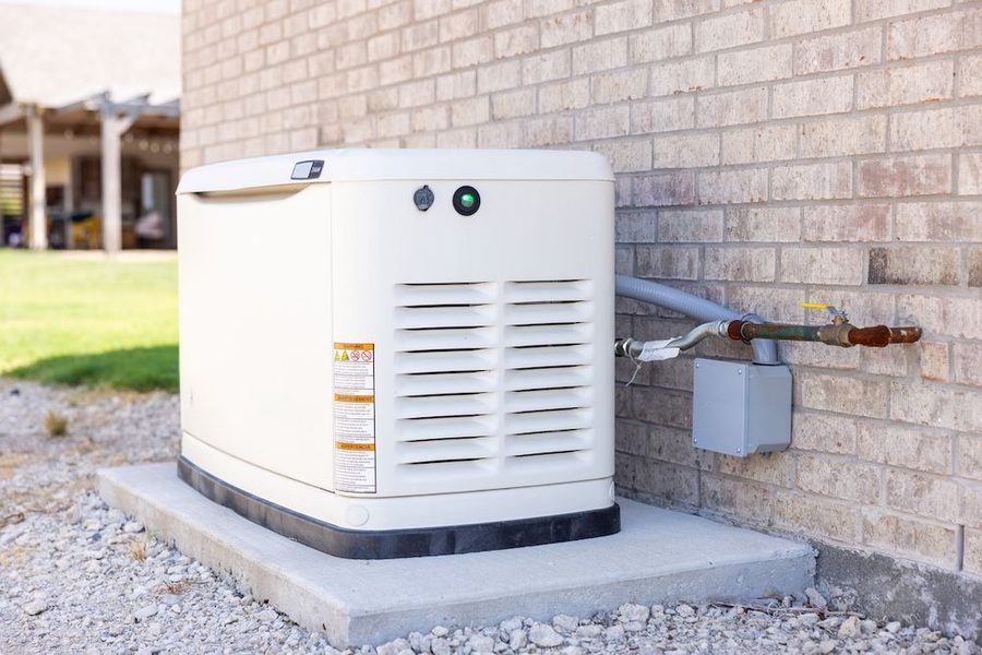 standby generator sitting on concrete slab outside a home