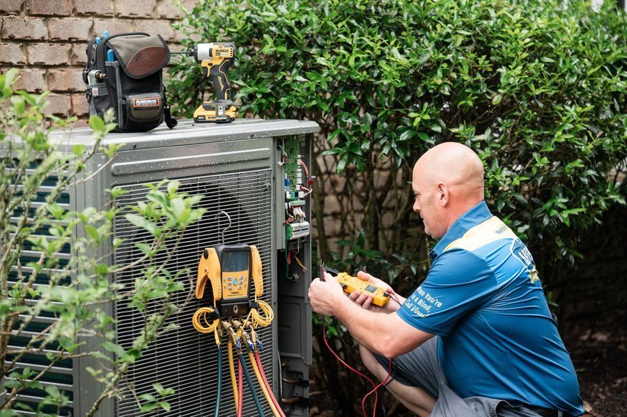 Vines technician repairing an AC unit