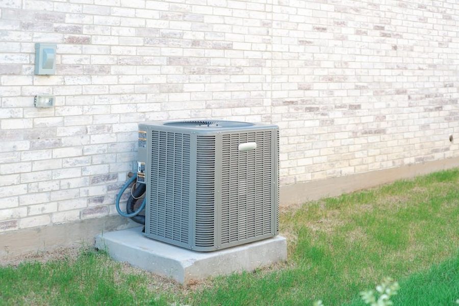 Outdoor air conditioning unit on a concrete slab on the side of a house